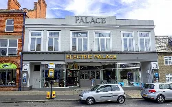 El cine Electric Palace con grandes ventanas y un cartel sobre la entrada.
