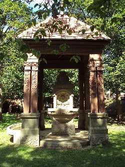 Memorial de piedra con una fuente en un quiosco en un parque.