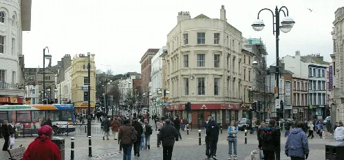 Crowded town centre with shops and people in Hastings, East Sussex.