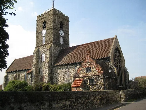 Iglesia de piedra con torre y reloj en Sandwich, Kent.