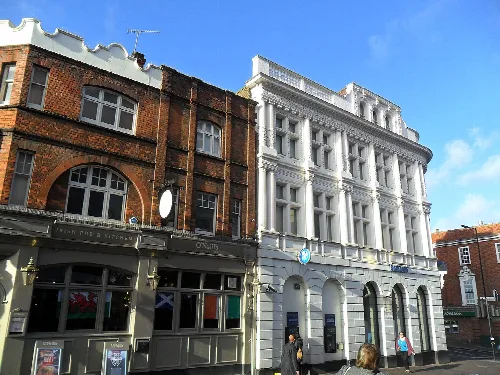 Vista de Sutton High Street con tiendas y peatones, edificio blanco y estructuras de ladrillo.