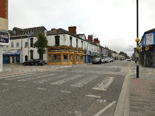 Zebra crossing on Freeman Street with shops and buildings.