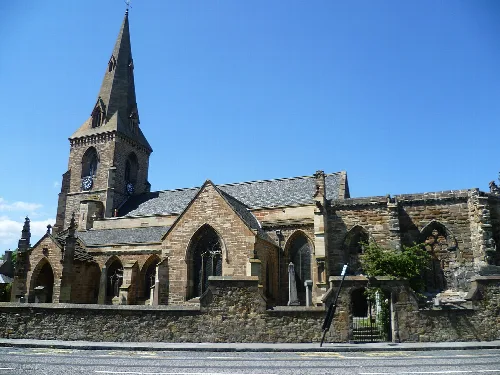 Iglesia de piedra con torre alta y ventanas arqueadas en Dalkeith.