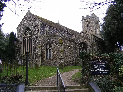 Stone church with a tower and arched windows in Halesworth.