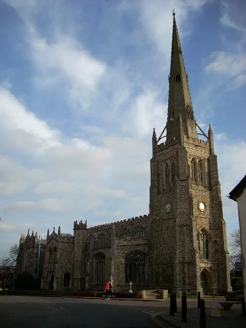 Iglesia de piedra con torre alta y reloj, vista frontal en Thaxted.