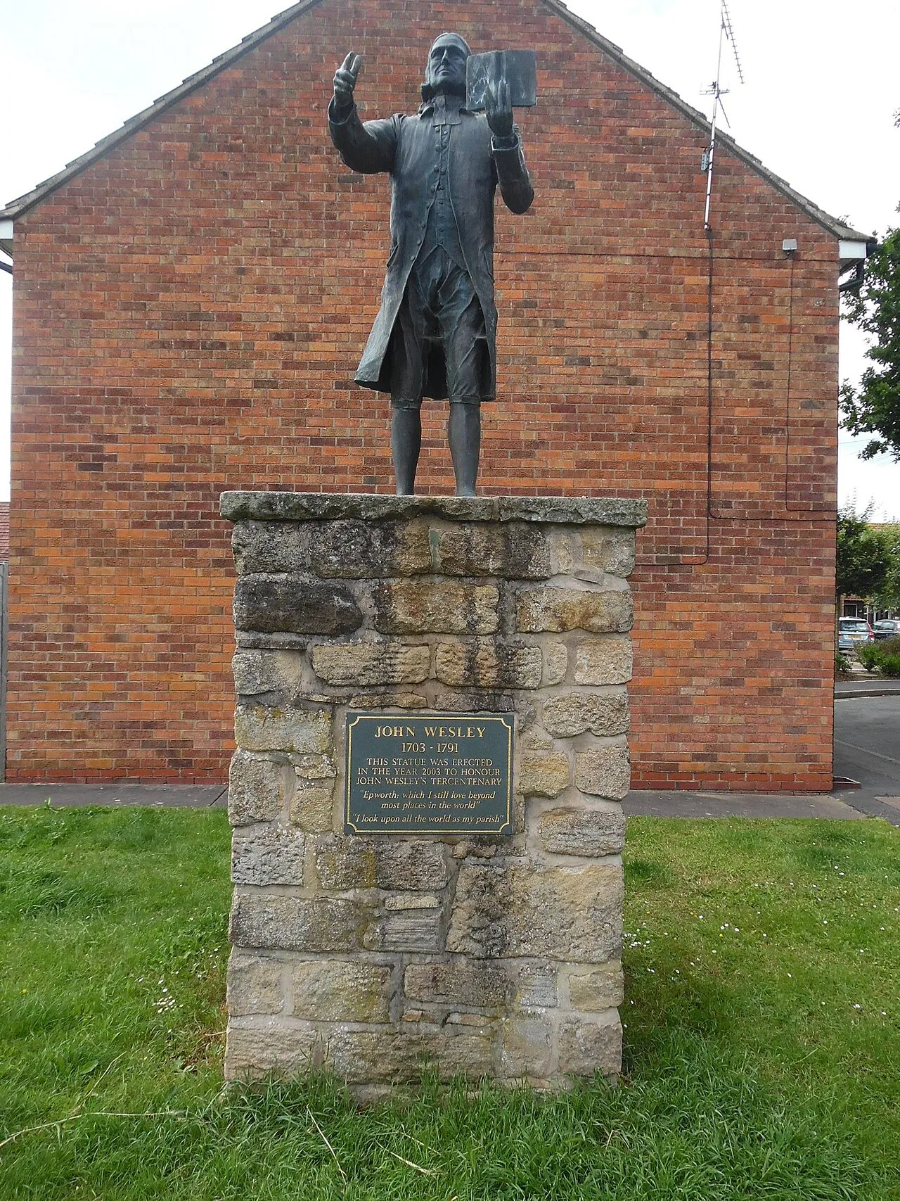 Bronze statue of John Wesley on a stone pedestal in Epworth.