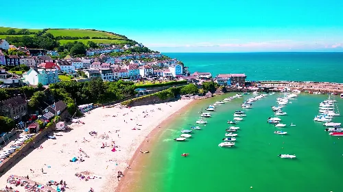 Playa de arena con barcos y casas coloridas en New Quay.
