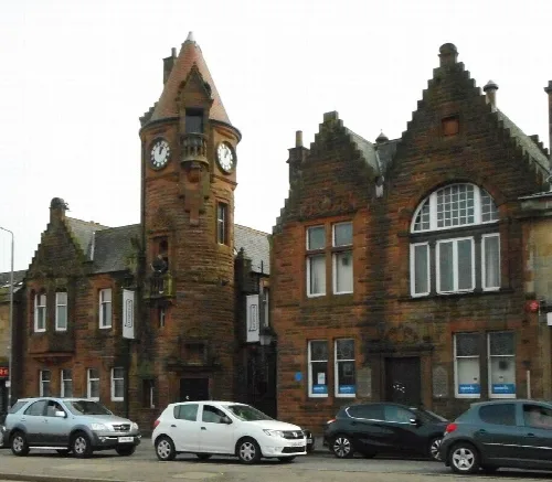 Gebäude aus rotem Sandstein mit Uhrturm und Bogenfenstern in Barrhead.