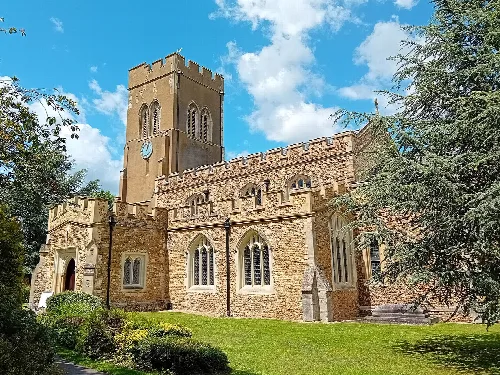 Stone church with a square tower and arched windows in Stotfold.