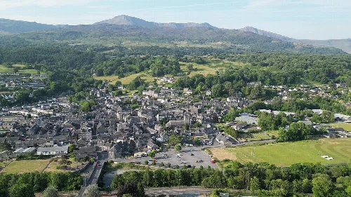 Vista aérea de Dolgellau con edificios, campos verdes y montañas.