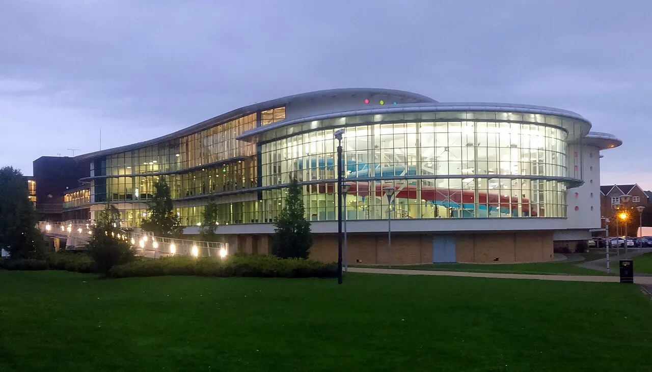Modern building with curved glass exterior and lights in Ashford.