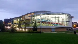 Modern building with curved glass exterior and lights in Ashford.