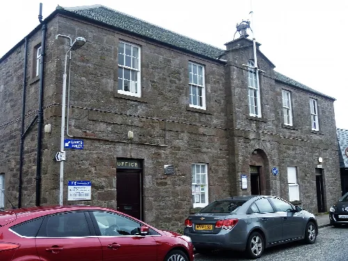 Stone town house with windows and a small tower in Inverbervie.
