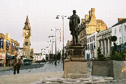 Statue im Stadtzentrum von Darlington mit Geschäften und historischen Gebäuden.