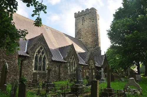 Iglesia de piedra con torre y cementerio en Haverfordwest.