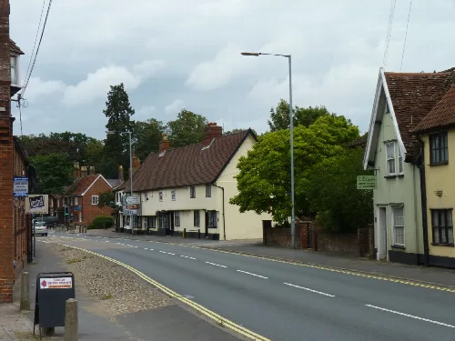 Una calle con edificios y árboles en Long Stratton, Norfolk.