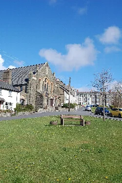 Salem-Kirche in Criccieth mit Grünfläche und Bank.