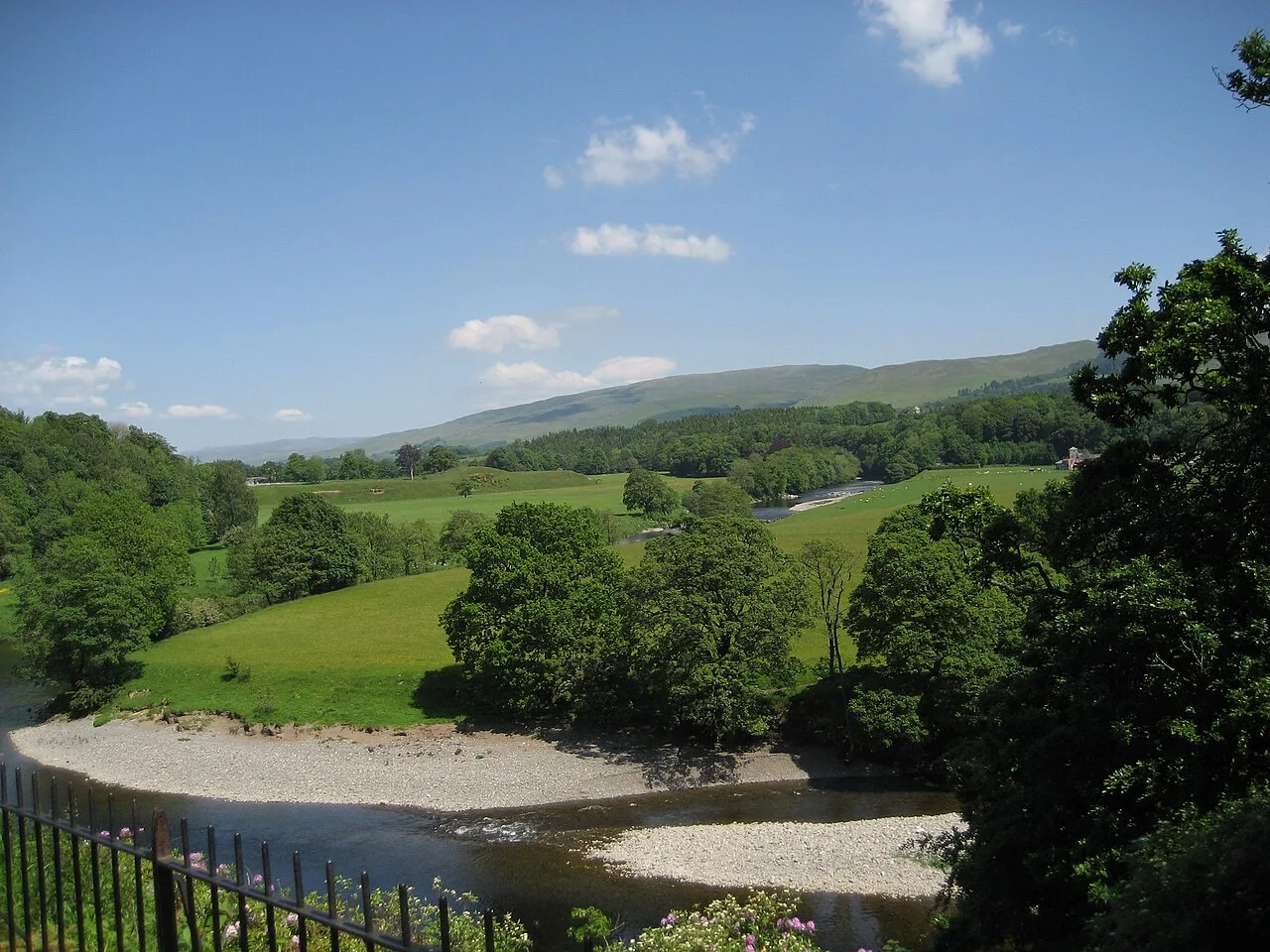 Scenic view of green fields, trees, and distant hills in Kirkby Lonsdale.