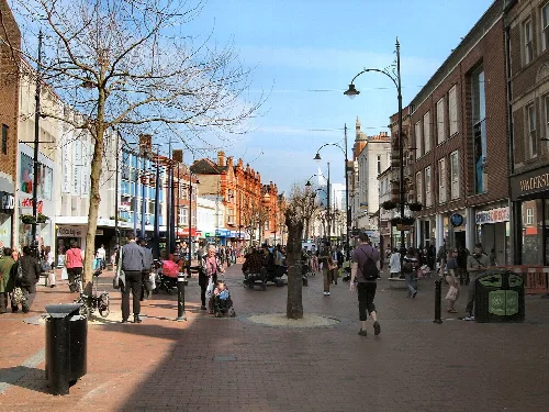 Fußgänger auf Broad Street in Reading mit Geschäften auf beiden Seiten.