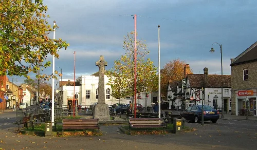 Town square with war memorial, benches, and shops in Biggleswade.