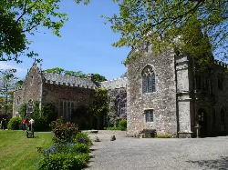 Stone hall with gothic windows and gardens in Cornwall.