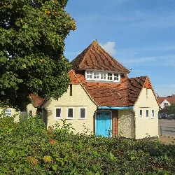 A small building with a red-tiled roof and a blue door in Letchworth Garden City.