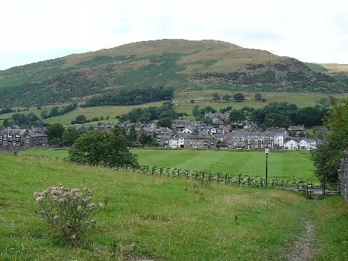 Village with green fields and hills in the background.