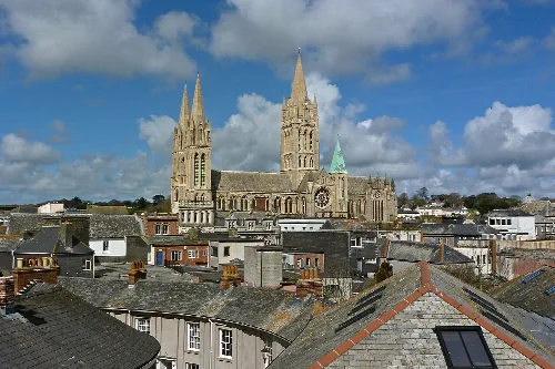 View of Truro Cathedral with tall spires above rooftops.