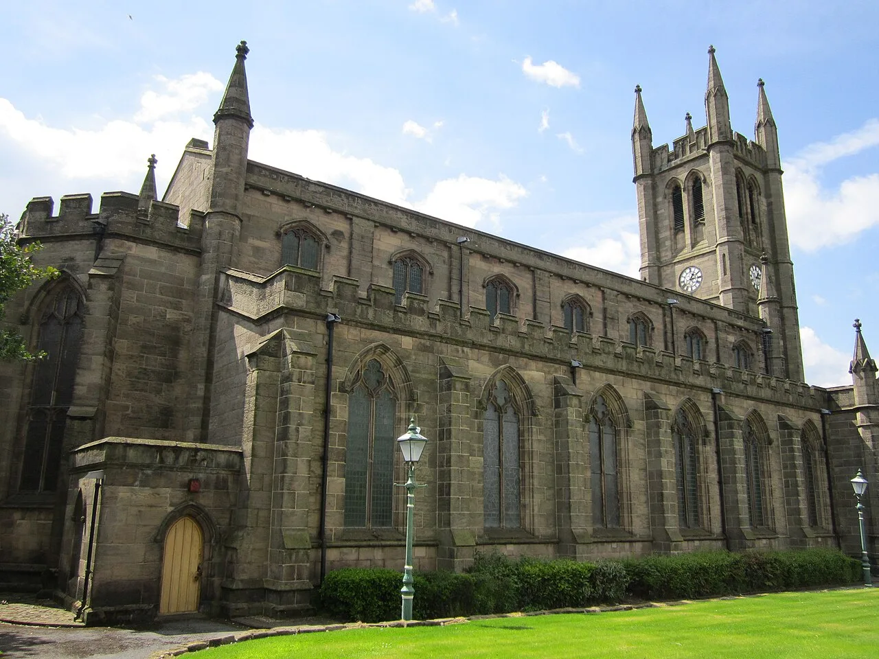 View of St James and St John church with tall tower and gothic windows from the east.