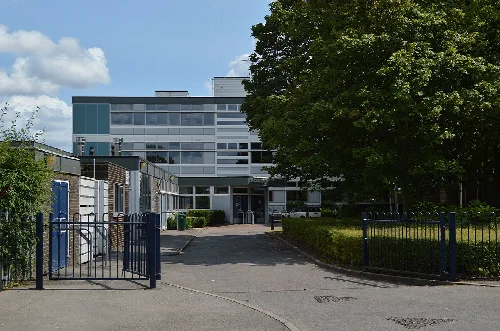 Modernes Schulgebäude mit Tor und Bäumen in Yateley.