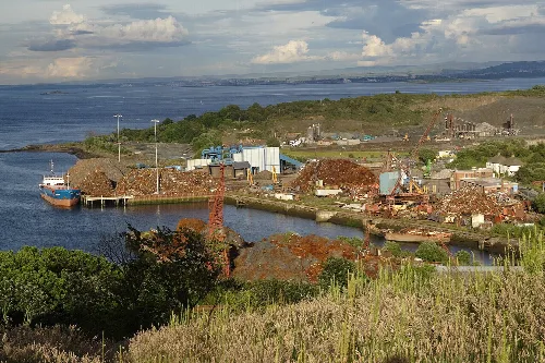 Harbour scene with ships, industrial area, and water in the background.