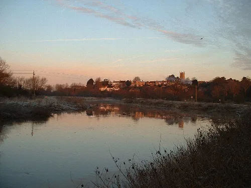 River Parrett with reflections of the town and sky at sunset.