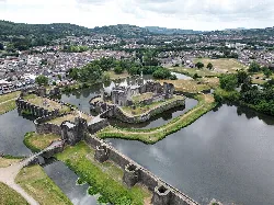 Vista de dron del castillo de Caerphilly con agua y paisaje verde.