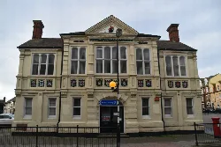 A historic town hall building with decorative shields and a pediment in Cromer.