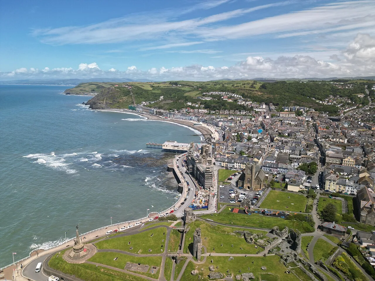 Vista aérea de la costa, paseo marítimo y colinas de Aberystwyth.