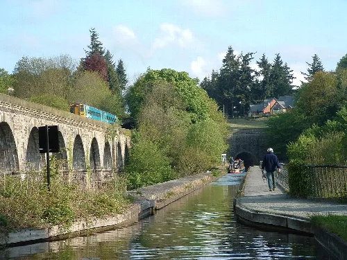 Tren cruzando un acueducto con personas caminando por el canal en Chirk.