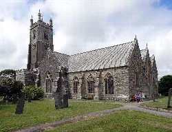 Stone church with a tall tower and graveyard.