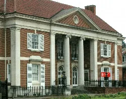 Un edificio de ladrillo con columnas blancas y varias ventanas, que sirve como oficina del ayuntamiento de Purley.