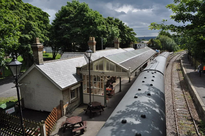 View of Stanhope Railway Station with a steam train and restored canopy.