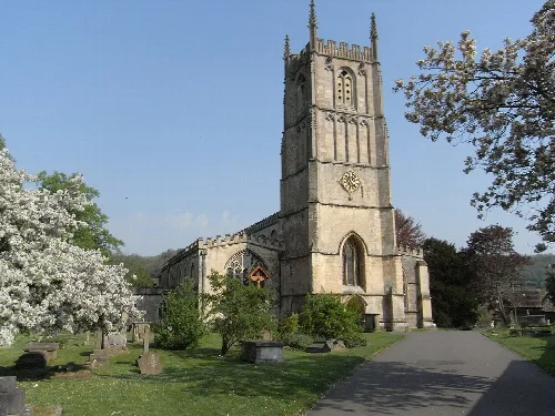 Church with tall tower, trees, and a pathway in Wotton-under-Edge.