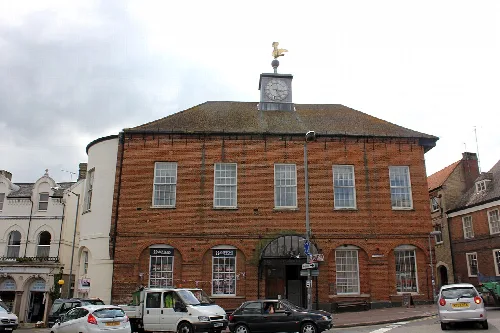 Backsteingebäude mit Uhrturm und Wetterfahne in Buckingham.
