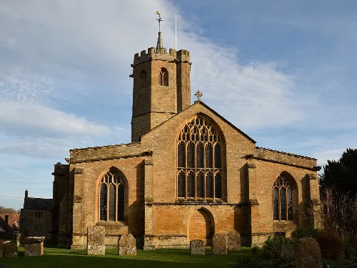 Iglesia de piedra con torre alta y grandes vitrales en South Petherton.