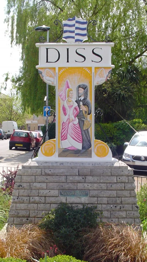 Señal en Diss con dos figuras medievales pintadas.