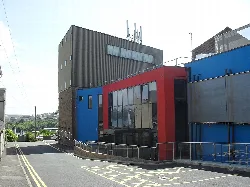 Edificio de teatro moderno con paneles rojos y azules en Milford Haven.