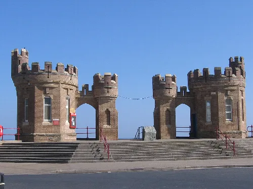 Stone towers with battlements and steps in front of them.