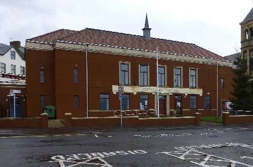 Rotes Backsteingebäude mit Schild und kleinem Turm in Portstewart.
