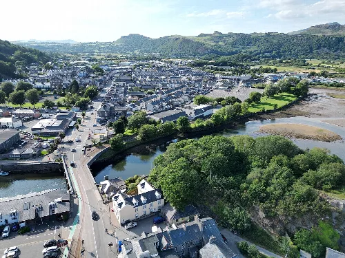 Luftaufnahme von Porthmadog mit Stadt, Fluss und Hügeln.
