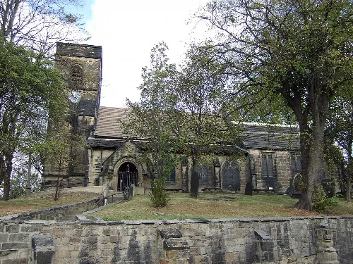 Steinernes Kirchengebäude mit Turm und Bogenfenstern in Hemsworth.