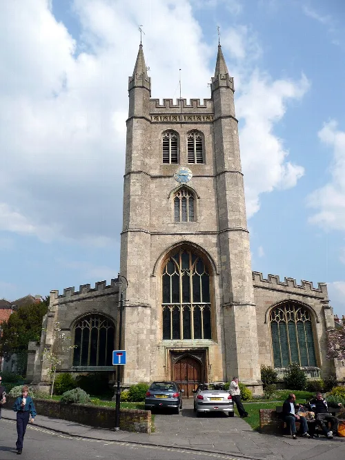 Front view of St Nicholas' church with tall towers and large stained glass windows.