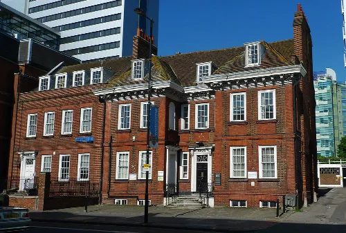 Edificio de ladrillo rojo con marcos de ventanas blancos en High Street, Croydon.